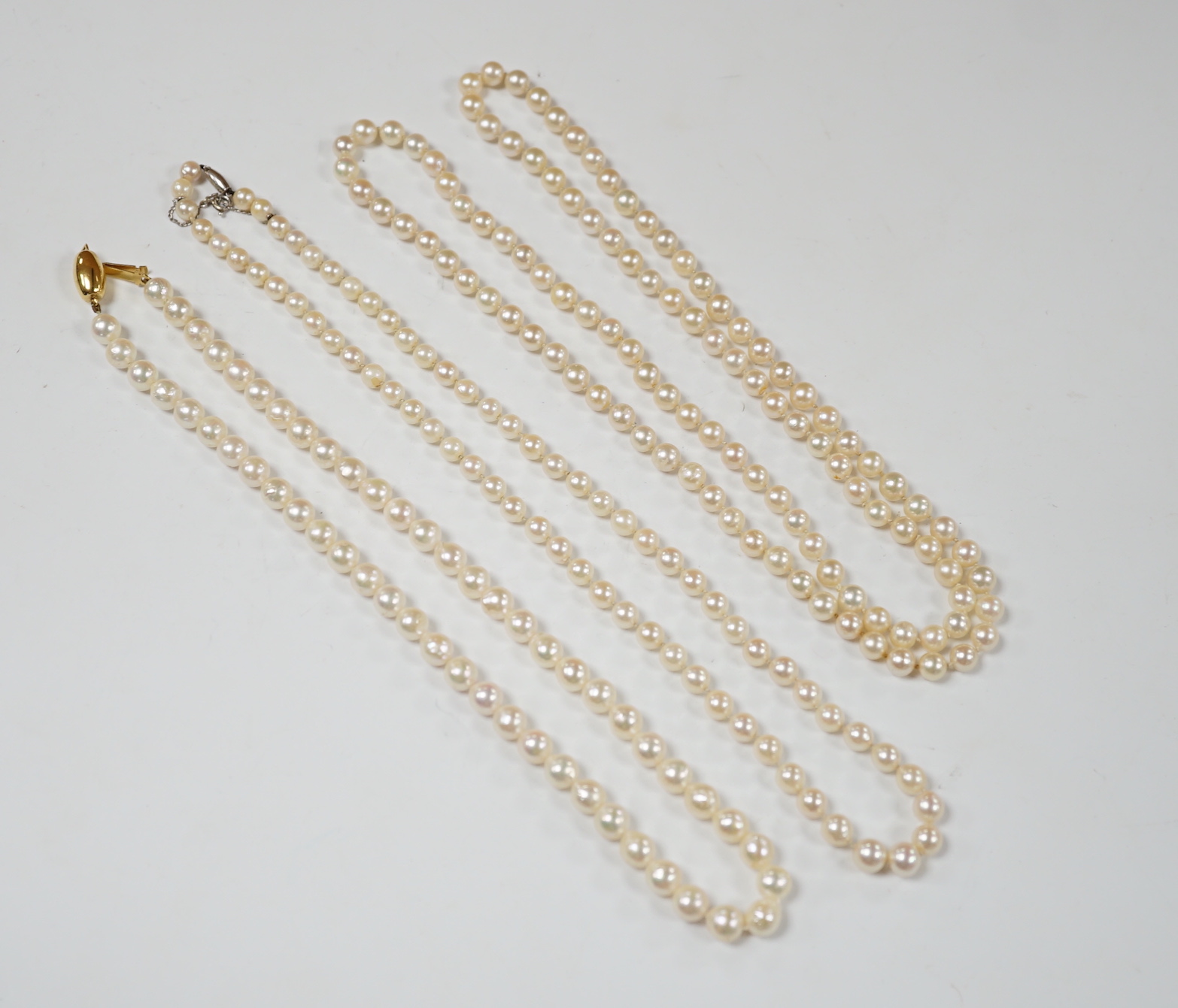 Three assorted modern single strand cultured pearl necklaces, one with 585 clasp, longest 76cm.